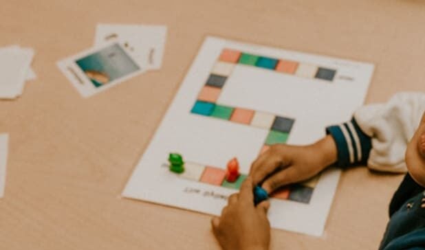 Niño sonriendo mientras está sentado en una mesa