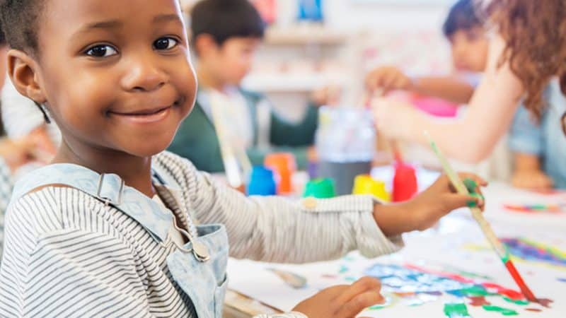 Young child painting in classroom