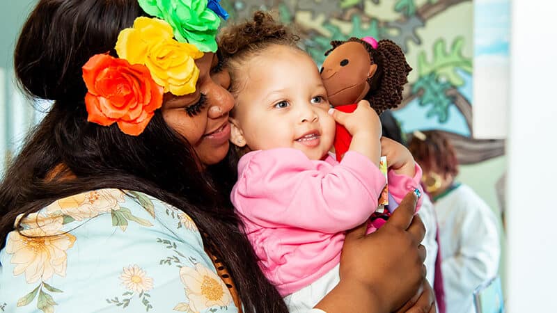 Young child being held by child care provider