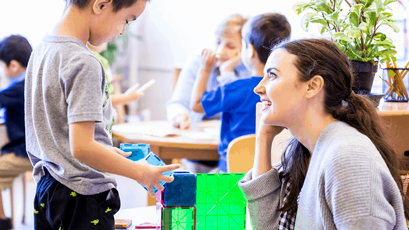 Boy and teacher playing with blocks